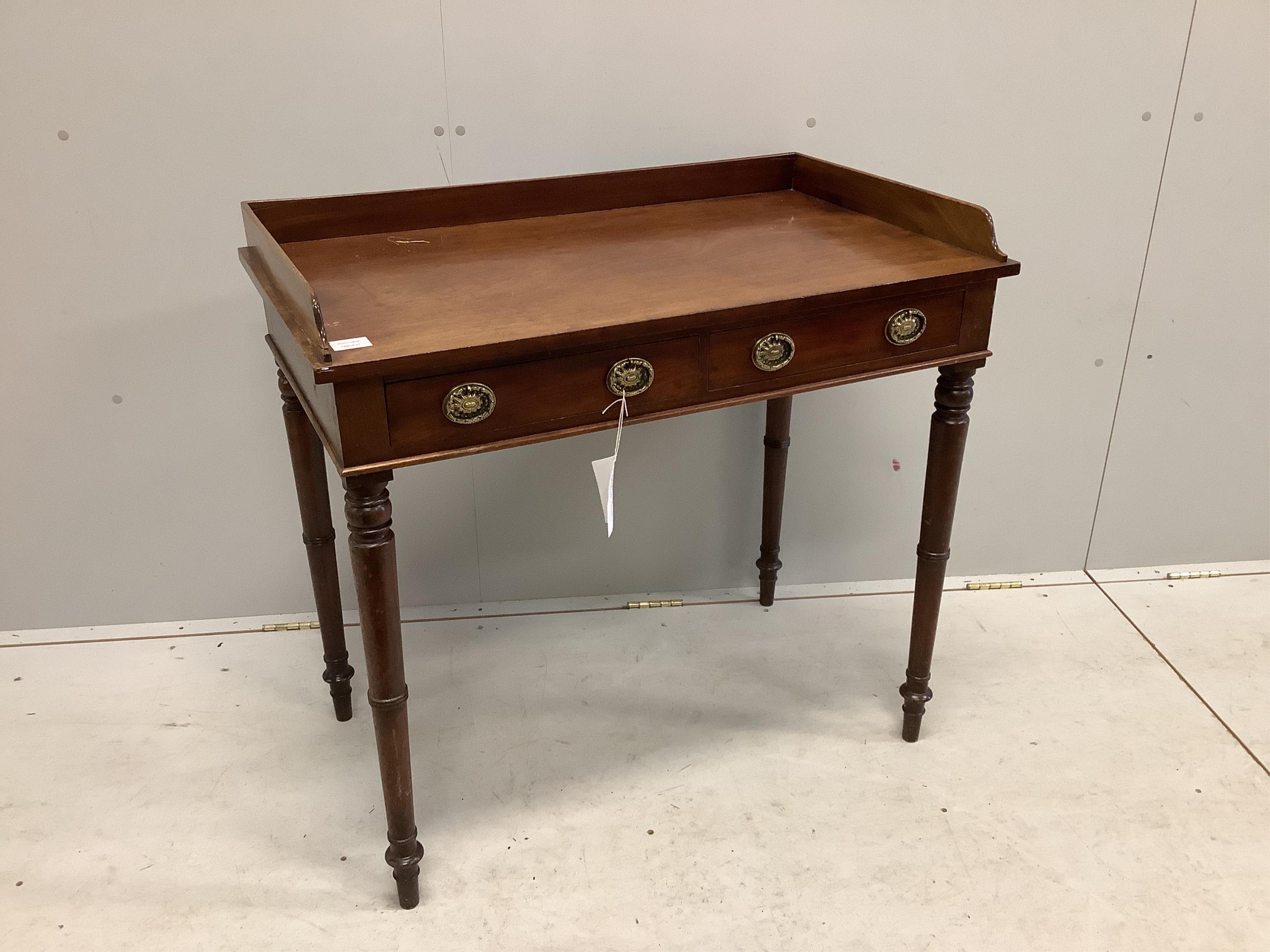 A Regency mahogany two drawer dressing table with a galleried top, on ring turned legs, width 91cm, depth 53cm, height 86cm. Condition - poor, one side to the gallery top is broken